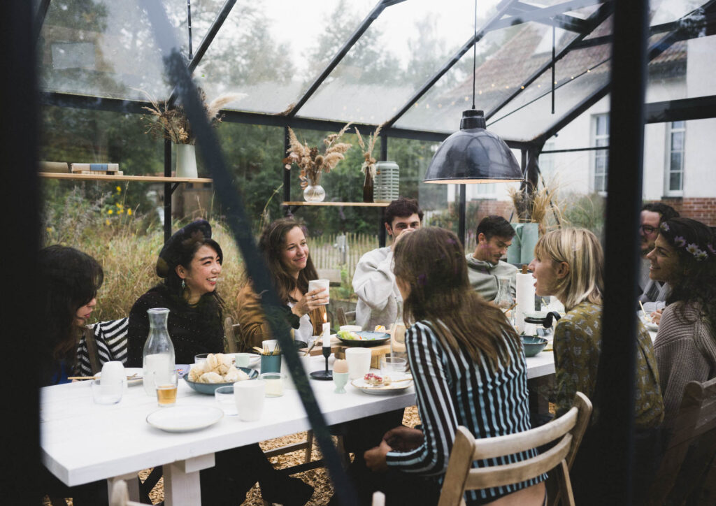 Eine Gruppe von Teilnehmern frühstückt in der Orangerie von Bahnhofszeit, umgeben von rustikalem Charme und natürlicher Dekoration. Foto: Maria Bayer https://www.mariabayer.de